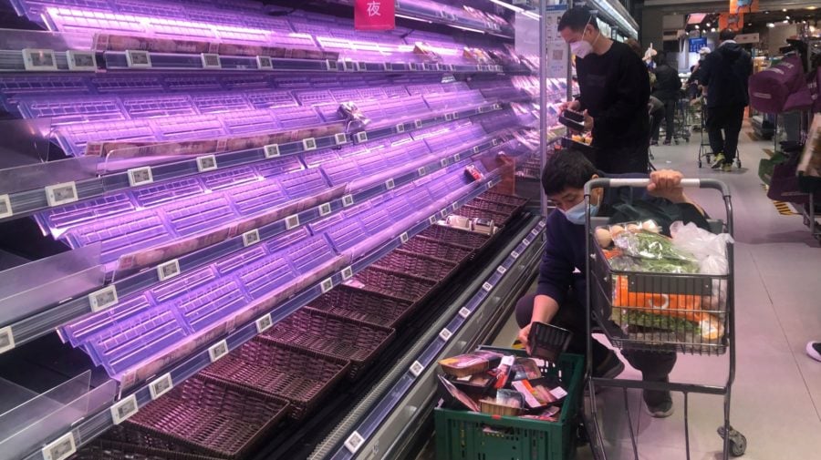 Zákazníci sa pozerajú na prázdne regály v supermarkete v čínskom Šanghaji 30. marca 2022. Úrady v Šanghaji začali v stredu uzatvárať niektoré oblasti na západe tohto najľudnatejšieho čínskeho mesta o dva dni skôr, ako pôvodne plánovali. Dôvodom pre lockdown je rýchle šírenie nového koronavírusu, ktorým sa za uplynulý deň nakazilo rekordných takmer 6000 osôb.