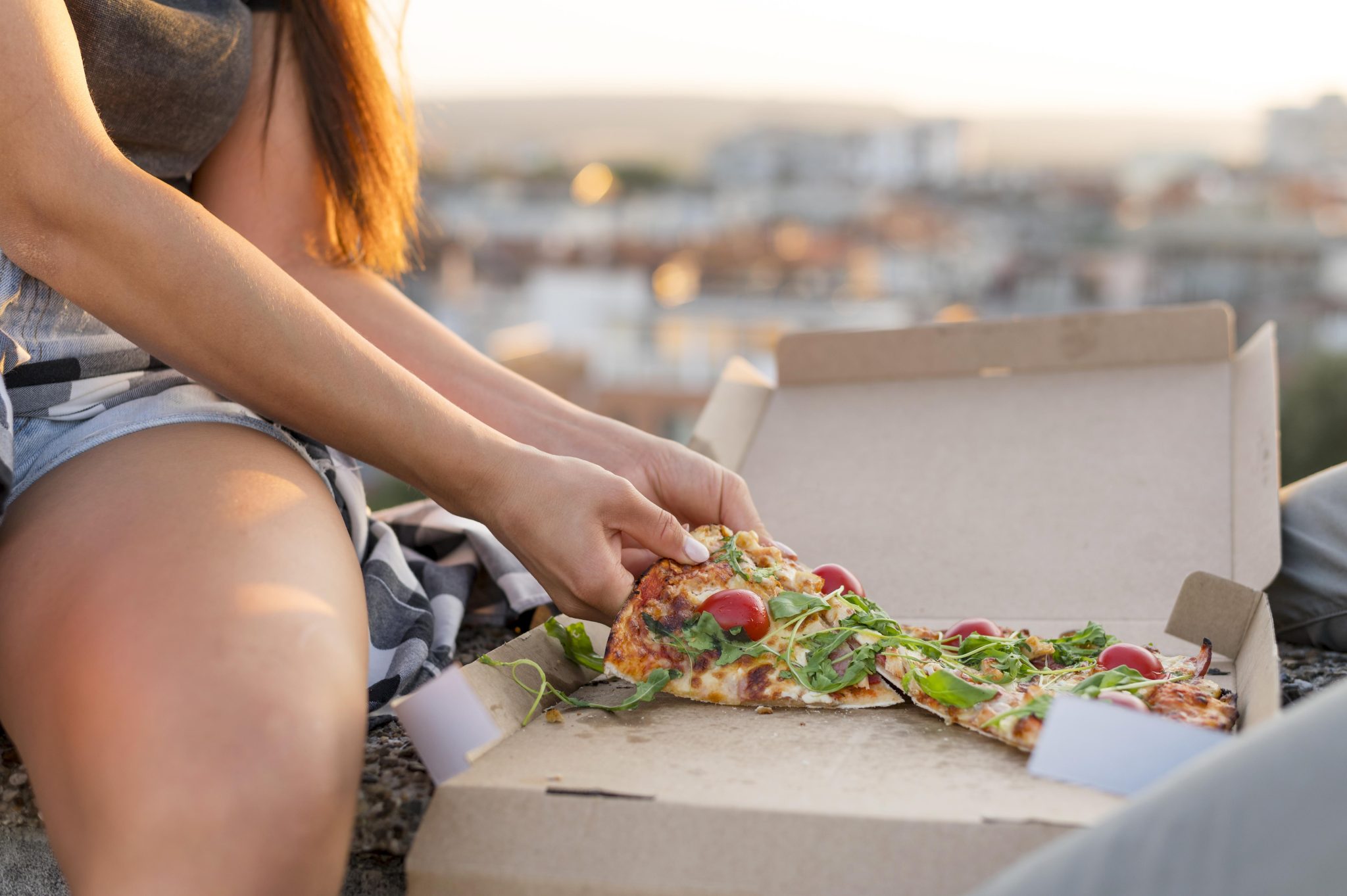 woman-eating-pizza-outdoors