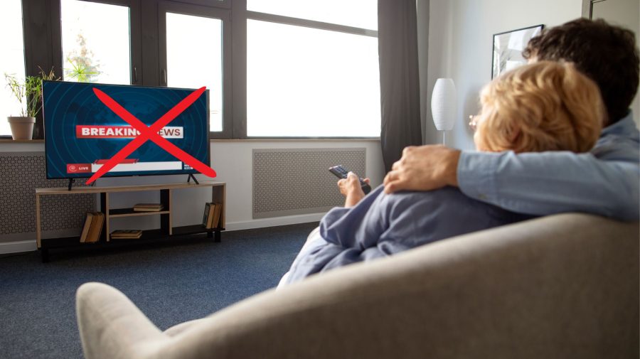 Ľudia na gauči pozerajú televíziu.